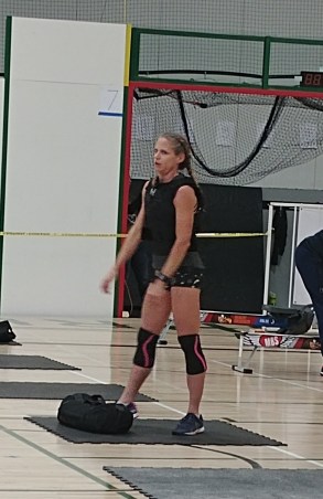 Hot CrossFit Chicks wearing weight vest and hoisting sand bag