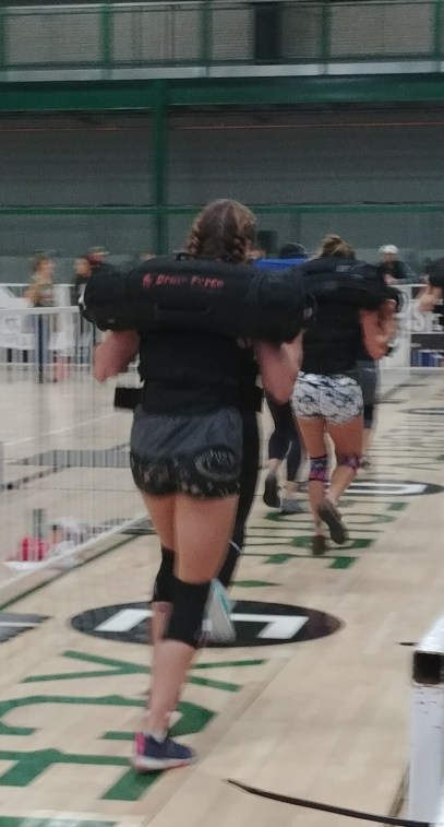crossfit chicks working out during crossfit competition with sandbags